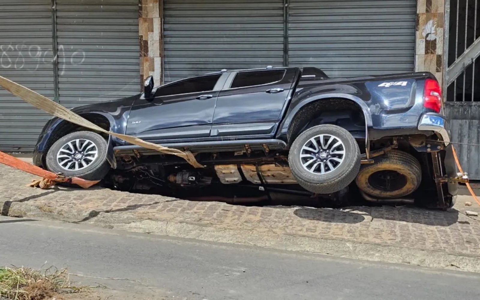 Carro estacionado cai em cratera após asfalto ceder na BR-420, em Mutuípe