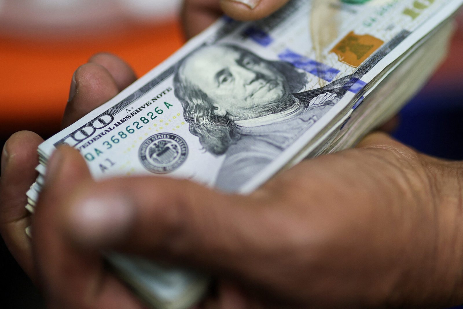 Dólar abre em queda, com petróleo e tarifaço no radar